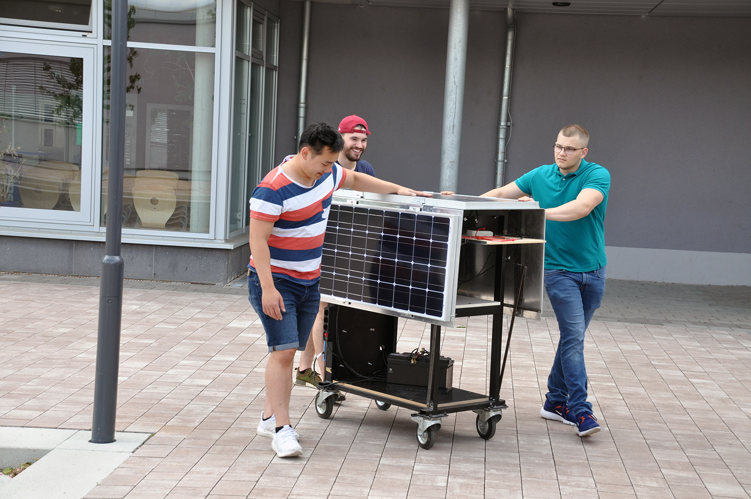 Benjamin Rapp, Kevin Weilbacher, beide ehemalige Schüler der Werner-Heisenberg-Schule, und Andreas Nguyen (2020 Student an der Hochschule RheinMain 2020) präsentieren die solare Inselladestation. Die Station wurde 2020 mit dem dritten Platz beim Wettbewerb ausgezeichnet.