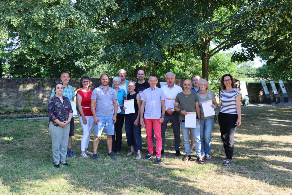 Sie sind jetzt klimafit: Landrat Thomas Will (Mitte), die stellvertretende Leitung der KVHS Silvia Parra Belmonte (links) und Thomas Münstermann (Sparkassen-Stiftung Groß-Gerau, neben Landrat Will) konnten fünfzehn Teilnehmer*innen eines Klima-Kurses bei der Kreisvolkshochschule Groß-Gerau ihre Urkunden überreichen. Foto: Kreisverwaltung